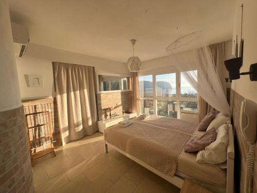 een slaapkamer met een groot bed en een groot raam bij Mahakala Center in Petrovac na Moru