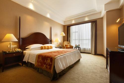 a hotel room with a bed and a large window at Grand Royal Hotel in Guangzhou