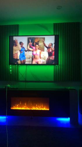 a living room with a tv above a fireplace at Luxury 1 Bedroom Back House In Lakeside in West Thurrock
