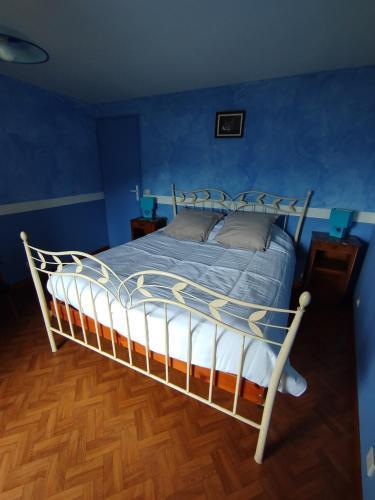 a bedroom with a bed with a blue wall at Les Balcons de Valezan in La Plagne Tarentaise