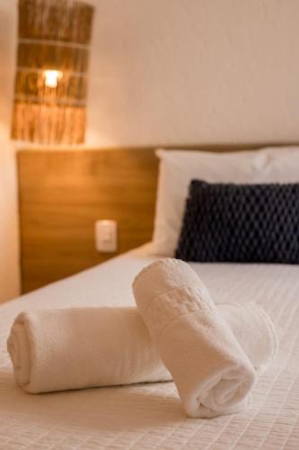 - une serviette blanche sur un lit dans la chambre dans l'établissement Casa Vilas Patacho Garden, à Porto de Pedras