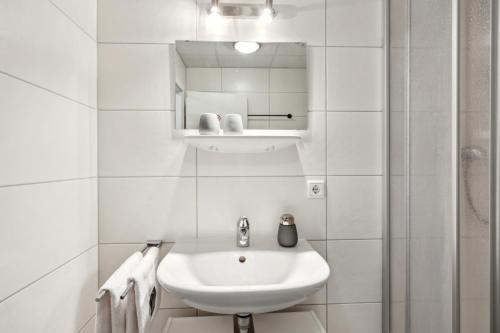 a white bathroom with a sink and a mirror at HanseStay Wandsbek in Hamburg