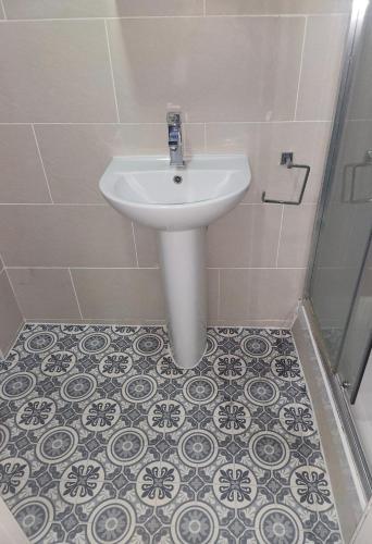 a bathroom with a white sink and a shower at Dodi Aparts London, near Stratford close to tube station in London