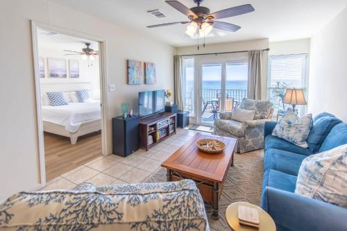 un soggiorno con un divano blu e un tavolo di Whispering Sands #202 a Coffeyville