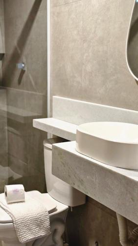 une salle de bains avec lavabo, toilettes et miroir dans l'établissement Chalés Feliz Boipeba, à Cairu