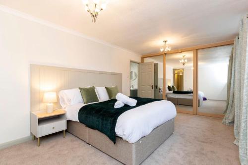 een slaapkamer met een groot bed en een grote spiegel bij Hot Tub Free Parking 5 Bedroom Large Space in Darlington