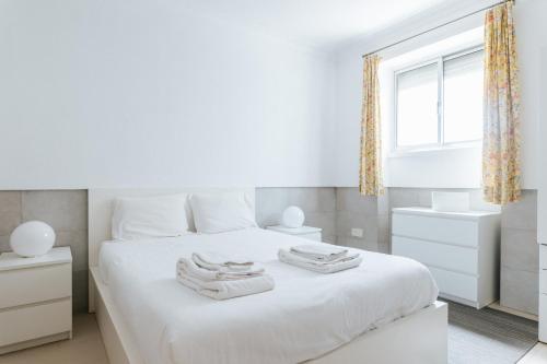 a bedroom with a white bed with towels on it at Lisbon Tagus River&Terrace Flat in Lisbon