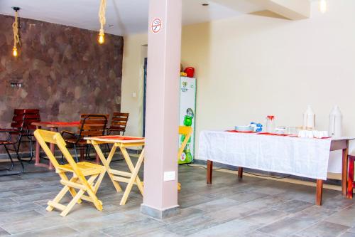 een eetkamer met een tafel en gele stoelen bij Mufasha Boutique Suites in Kisoro