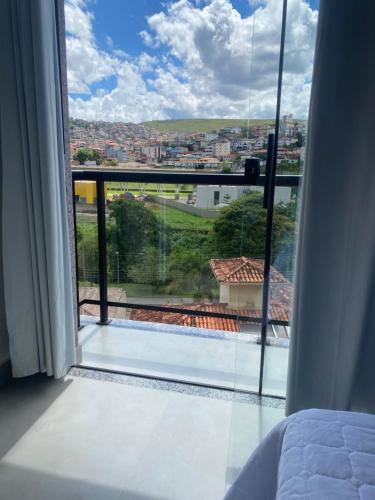 Schlafzimmer mit Stadtblick aus dem Fenster in der Unterkunft Apartamento em Mariana in Mariana