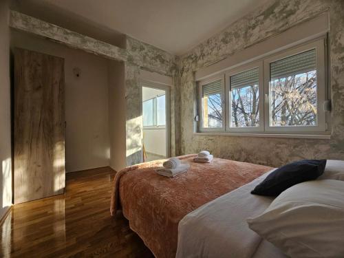 a bedroom with two beds and two windows at Modern Apartment - Capljina Center in Čapljina