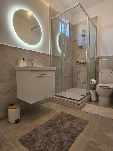 a bathroom with a shower and a toilet and a sink at Modern Apartment - Capljina Center in Čapljina