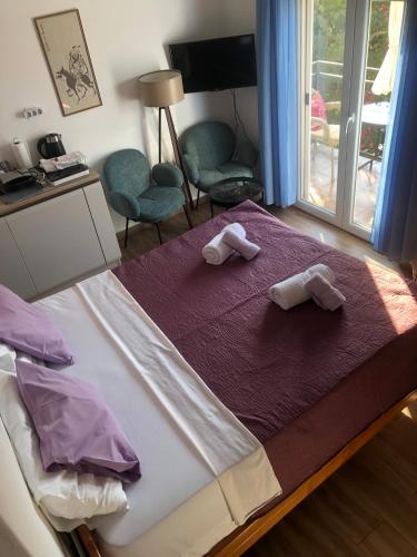 a bedroom with a bed with two towels on it at Villa Mia Apartments in Bijela