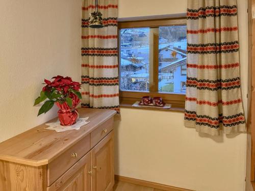 una cucina con una finestra e una credenza in legno con una pianta di Nussbaumer a Lengdorf