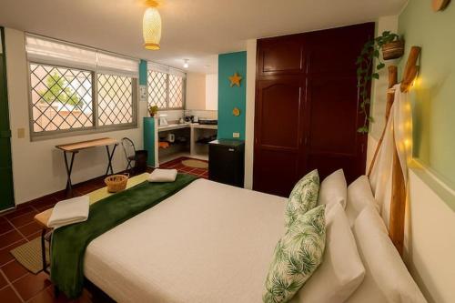 a bedroom with a large bed and a kitchen at La Magia del Atardecer - Studio 02 in Santa Marta