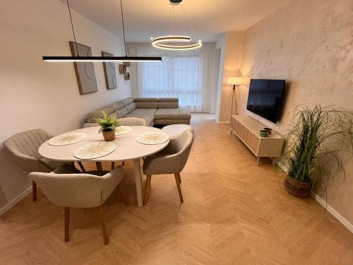 a living room with a table and chairs and a couch at Spa Apartman Bardejovské kúpele s dvoma izbami in Bardejovské Kúpele