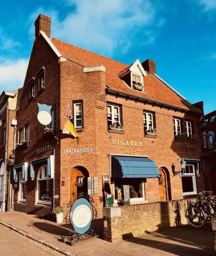 a brick building with a sign in front of it at De Kleine Vesting Arcen in Arcen
