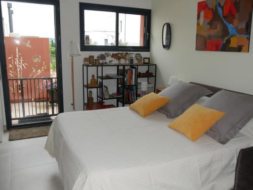 a bedroom with a white bed with two yellow pillows at L'Atelier du Champ Ladoit in Mercurey