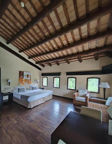 a large bedroom with a large bed and a couch at Molí Blanc Hotel in Jorba