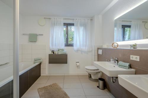 a bathroom with a sink and a toilet and a tub at Konny in Gaienhofen