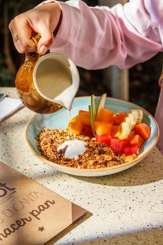 eine Person, die einen Drink in eine Schüssel Essen gießt in der Unterkunft Hotel Libreria Cafe de Pombal in Santa Marta