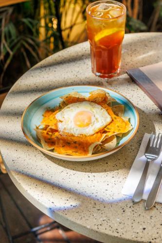 ein Teller mit Essen und einem Ei auf einem Tisch in der Unterkunft Hotel Libreria Cafe de Pombal in Santa Marta