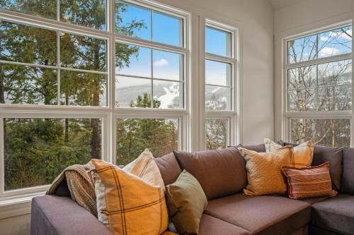 a couch with pillows in a room with windows at Tremblant Prestige - Les Eaux 221-3 in Mont-Tremblant