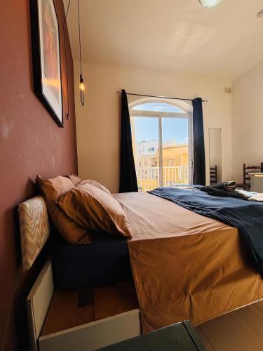een bed in een kamer met een raam bij Sliema Central with Balcony Airconditioned and Comfortable Self Check IN in Il-Gżira