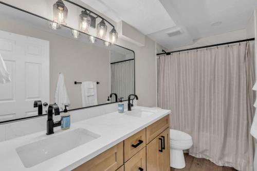 a bathroom with a sink and a toilet and a mirror at Lehi High Luxe Views and Sky in Lehi