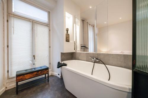 een badkamer met een wit bad en een raam bij Hyper centre Cannes - 2 pièces avec balcon - 4 couchages in Cannes