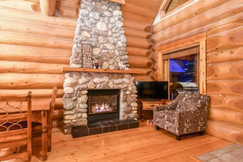 a living room with a fireplace in a log cabin at Authentic, Timber Log Cabin Perfect for Groups in Golden