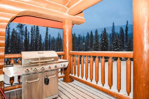 a grill on a deck with a view of the mountains at Authentic, Timber Log Cabin Perfect for Groups in Golden