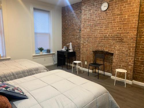 una camera da letto con un muro di mattoni e un camino di Aycee 417 a New York