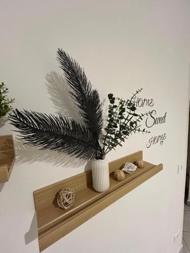 a plant in a vase on a shelf on a wall at Home Sweet Home Forli in Forlì