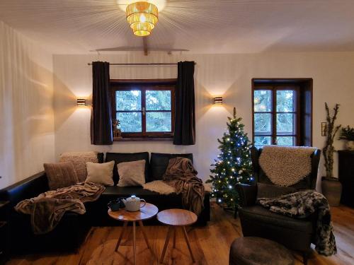 a living room with a christmas tree and a couch at Chalet Alpl - Ferienwohnung Waldblick mit Sauna, Kamin & Whirlwanne in Hochrindl