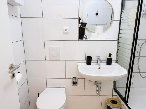 een witte badkamer met een toilet en een wastafel bij Kölner Street Loft ,Neu Renoviert für bis zu 5 Personen mit Küche und Bad in Düsseldorf