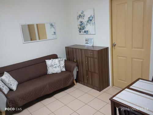 伊洛伊洛One Spatial-Iloilo Condo B2U2220的客厅里有一张棕色沙发和一个木制橱柜