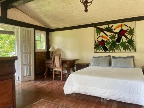 una camera da letto con un letto, una scrivania e un tavolo di Fazenda Vista Soberba a Nova Friburgo