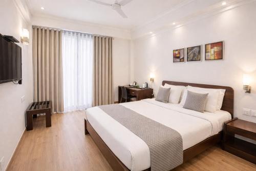 a bedroom with a large bed and a television at EMBLEM Hotel - Arjun Marg, Golf Course Road, Gurgaon in Gurgaon