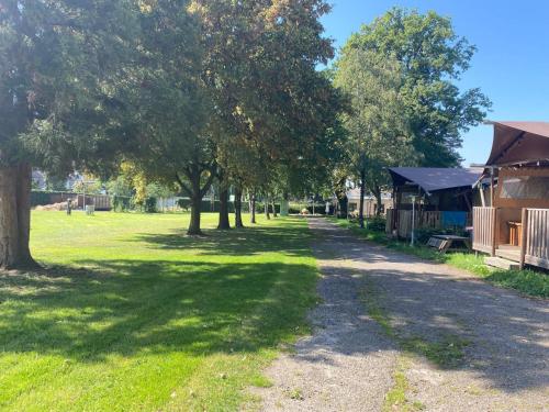 eine unbefestigte Straße in einem Park mit Bäumen und Gebäuden in der Unterkunft Het Heideverblijf in Heerlen