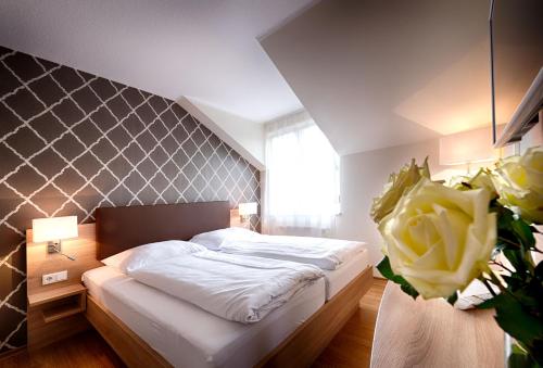 a bedroom with a bed and a flower in a room at Dom Hotel in Gescher