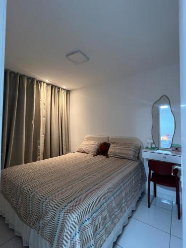 a bedroom with a bed with a mirror and a desk at Apt 424 in João Pessoa