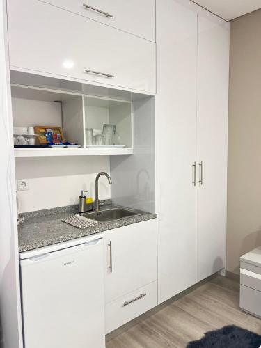 a kitchen with white cabinets and a sink at Casa da Moagem in Vinhais