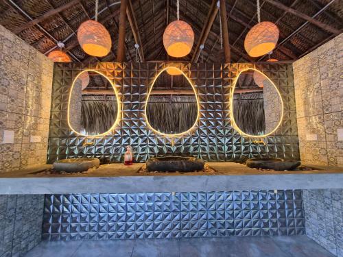 una stanza con finestre circolari e luci sul muro di Dos Peladas Hostal a Santa Marta