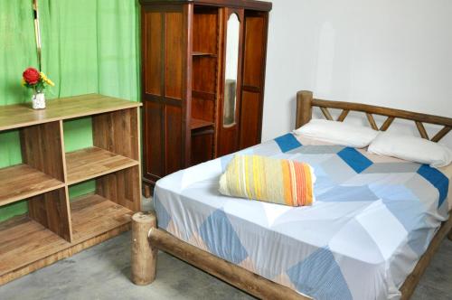 - une chambre avec un lit en bois et un oreiller dans l'établissement Pousada pantera do rosa, à Imbituba