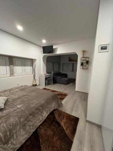 a bedroom with a large bed and a living room at Casa da Moagem in Vinhais