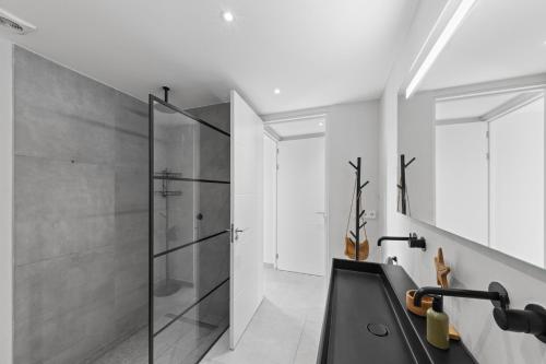 ein Badezimmer mit Glasdusche und Waschbecken in der Unterkunft The Grand in Jan Thiel