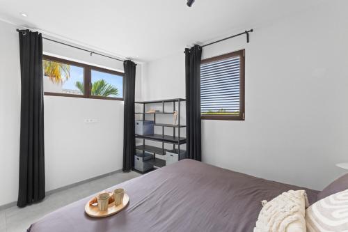 ein Schlafzimmer mit einem Bett und einem Tablett mit Schuhen darauf in der Unterkunft The Grand in Jan Thiel