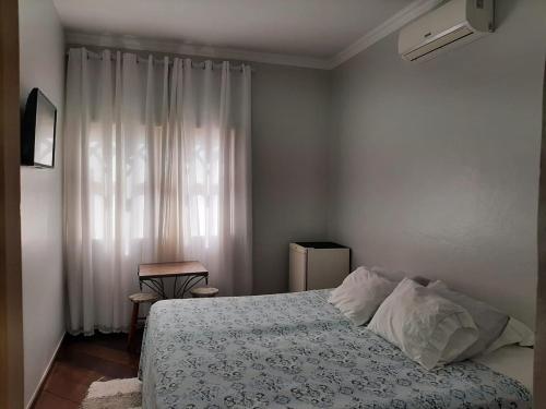 una camera da letto con un letto e una finestra di Pousada Tartaruga Marinha a Ubatuba