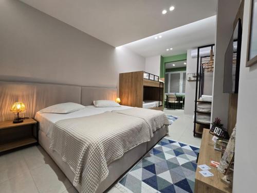 a bedroom with a large bed and a living room at Elite Guesthouse in Tirana