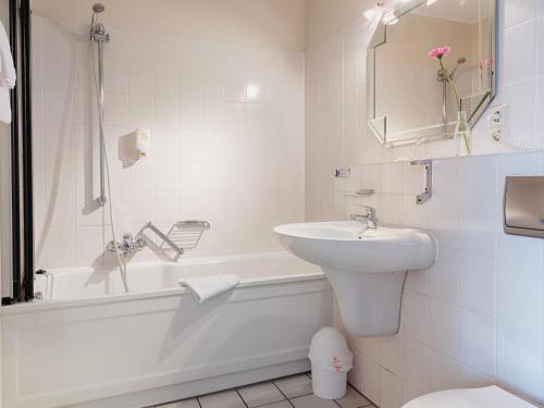 ein Badezimmer mit einem Waschbecken, einer Badewanne und einem WC in der Unterkunft Dom Hotel in Gescher